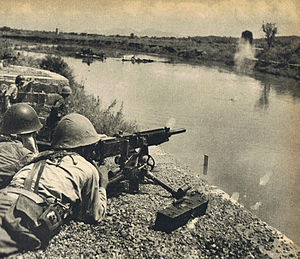 Японский солдат стреляет из пулемёта через реку Милуо