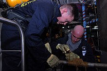 Machinist's Mates repairing a simulated cracked pipe with soft patch during a general quarters drill aboard USS Ronald Reagan US Navy 080827-N-3610L-114 Machinist's Mate 3rd Class Michael Scholten and Machinist's Mate 3rd Class Kyle Auger-Albanese repair a simulated cracked pipe.jpg