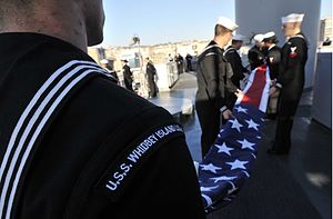 US Navy 120117-N-AG285-180 Sailors aboard the amphibious dock landing ship USS Whidbey Island (LSD 41) fold the American flag after arriving at Nap.jpg