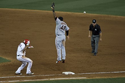 A throw is airmailed over the head of San Francisco Giants first baseman Pablo Sandoval.
