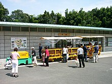 Aka station and battery locomotive hauled train.jpg