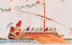 Et fargerikt bilde av et fartøy med en mast, drevet av et stort antall roere. Mot akterenden av skipet holder en mann en batong hevet for å presse roerne til å ro