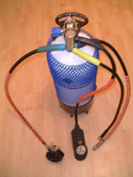 A single-hose regulator with 2nd stage, gauges, BC attachment, and dry suit hose mounted on a cylinder