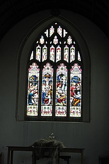 Picture of the stained glass window gifted by Sidney Hill to Axbridge parish church after its restoration in 1887. Four lights are shown representing Nativity, Crucifixion, Resurrection, and Feed my Lambs