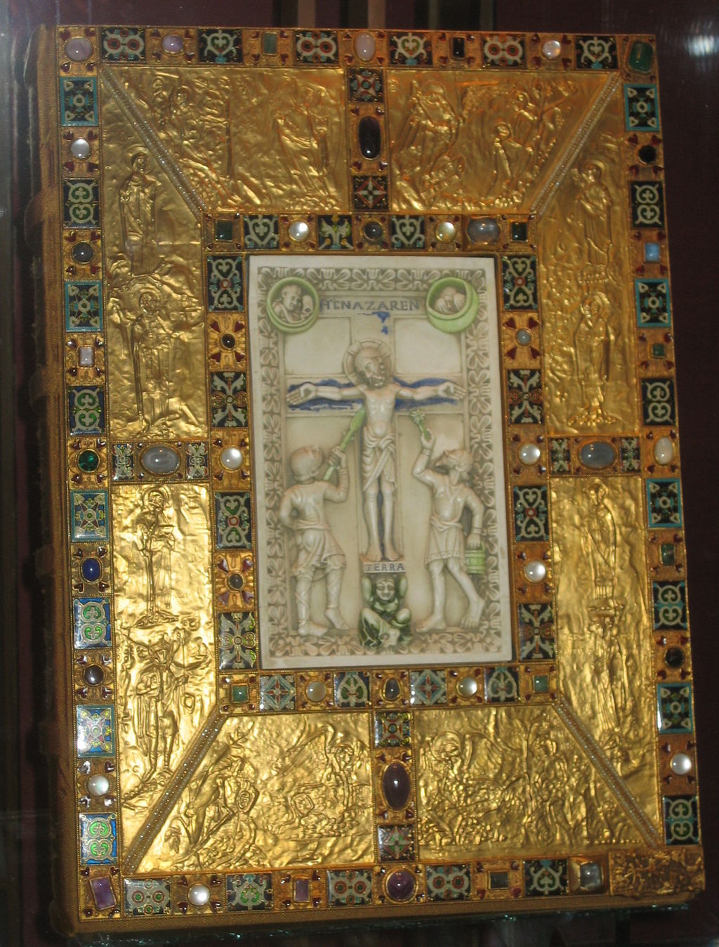 Codex Aureus abbey of Echternach: A large, rectangular art structure with religious imagery of Jesus in the center. Further, the background is in gold, while the center is depicted in a clean stone. 