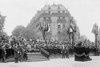 Photo en noir et blanc d'un homme discourant depuis une tribune, devant plusieurs rangées de personnes