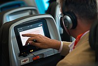 A man using a modern in-flight entertainment system