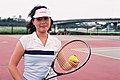 Female in Tennis clothing posing with Tennis ball and racket.jpg