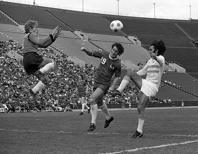 George Best (right) of the Los Angeles Aztecs challenges for the ball against New York Cosmos, 1976