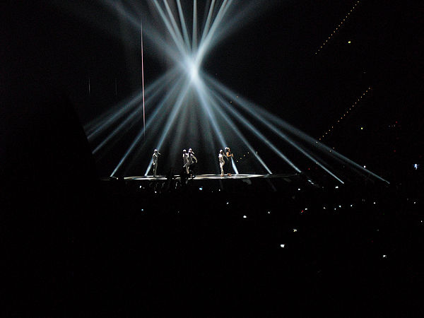 A screenshot of Lena's show at Eurovision. She performs on a dark stage in a "temple of white rays of light".