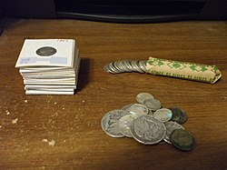 A selection of silver American coins. From the mid-1960s to the 1970s and onward, people began hoarding gold and silver coins to build wealth as a means to mitigate the results of a hyperinflation effect on the economy. JunkSilver.JPG