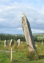 View of the megalithic complex at Knocknakilla in County Cork, with a stone row shown behind a 3.5 m portal stone Knocknakilla 25.jpg