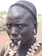 Femme mursi stigmate de labret et de disque auriculaire.