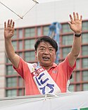 Nihi Souhei waves to greet voters in front of Hakata Station.jpg