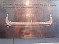 A low-quality picture of one of the object displays at the Viking ship museum, showing a sketch of the whole Oseberg ship.