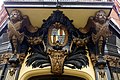 Coat of arms between angels above corner doorway