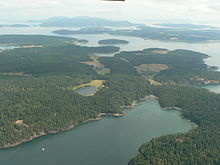 Most of the southern half of Shaw Island (looking to the east), with the much smaller Canoe Island immediately past it, then Lopez Island most prominent in the background Shaw Island.jpg