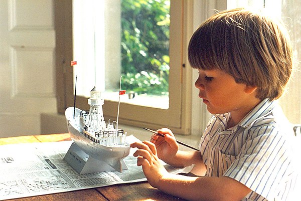 A young boy starts painting an assembled plastic model of the South Goodwin Lightship