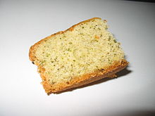 Photographie d’une tranche de gâteau avec des bouts verts.