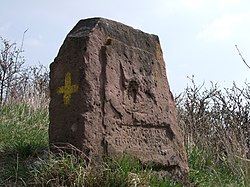 Stone cross with the yellow cross on the side