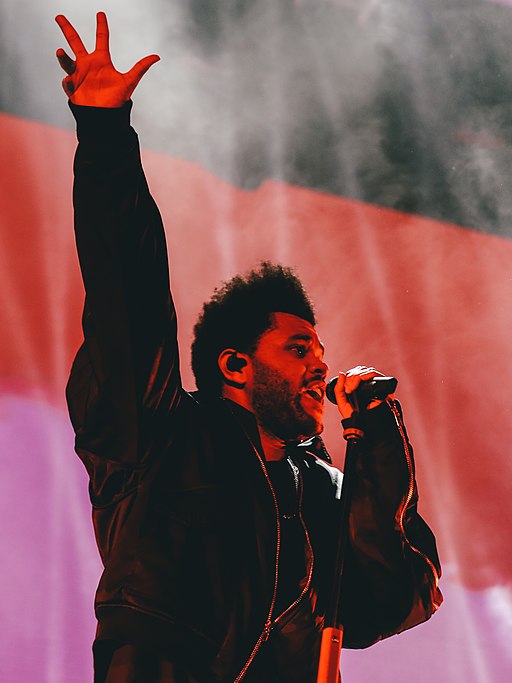 The Weeknd with hand in the air performing live in Hong Kong in November 2018 (cropped)
