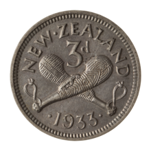 A silver coin with two crossed patu clubs, with the label "3D" above them. Below is the date, 1933, and arcing above is the text "NEW ZEALAND".