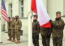 Soldiers of the 64th Brigade Support Battalion and Polish soldiers of the 35th Polish Air Defense Squadron prepare to raise the Polish and U.S. flags during a celebration ceremony welcoming American Forces. 64th Brigade Support Battalion in Poland.jpg