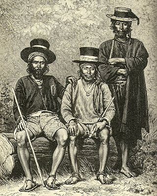 Two sitting men and one standing man. All wear a haedscarf and a hat and a stick in their hands.