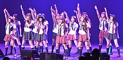 A series of girls performs on stage.