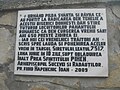 Placă de marmură pe zidul de piatră împrejmuitor, amplasată în 2009