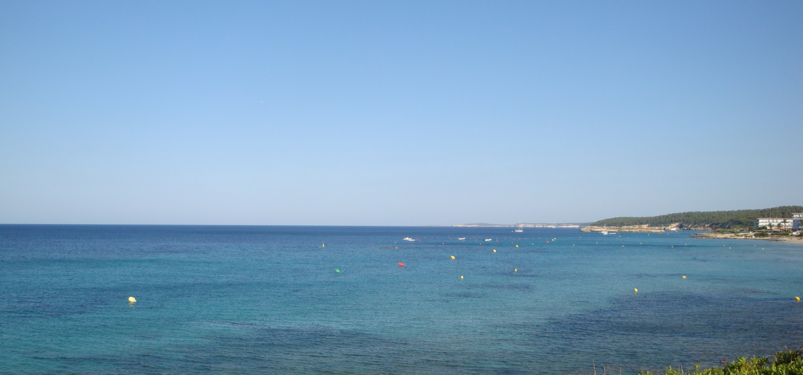 Leisure boaters outside the swimming buoys near the beach of Sant Tomas, Menorca