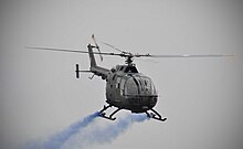 Bolkow BO105-CBS helicopter trails blue smoke during RBAirF / TUDB anniversary display at Royal Brunei Air Force Base, Rimba, 31 May 2009. Bolkow BO105-CBS of the Royal Brunei Air Force (RBAirF - TUDB) anniversary 2009, at Royal Brunei Air Force Base, Rimba - 4.jpg