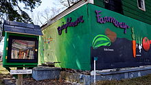 A home in Brightmoor painted with a map of the neighborhood. A community "free library" can be seen in the yard. Brightmoor Farmway.JPG