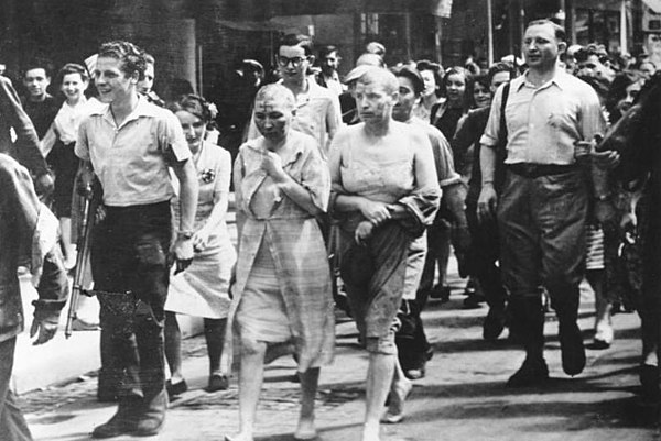 French women accused of collaborating with the Nazis being paraded through the streets barefoot, shaved, and with swastikas burned on their faces in 1