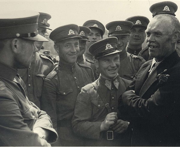 Soviet political leader (without military shoulder straps) and the puppet People's Seimas member (with red rose in his jacket lapel) announces to the 
