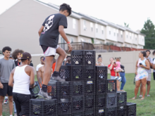 A man attempts to cross the pyramid-shaped crates Crate Challenge in Leeland Park.png