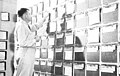 Task cargo officer examining shipping permit file in his office at the construction batallion center, Davisville, R.I. Equipment and supplies were covered by a shipping permit which provided essential information for preparing loading plans, shipping manifests and cargo handling plans.