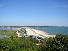 view looking down from a hill onto a sandy shoreline
