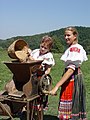 Z ruku ćěrjacy majsowy młyn při folklorowym festiwalu w Słowakskej.