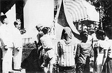 Hoisting of the original flag moments after the declaration of independence on 17 August 1945. Indonesian flag raised 17 August 1945.jpg