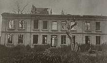 Mustavalkoinen valokuva suurelta osin tuhoutuneesta talosta