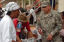 Maj. Liendo Alvaro, a Laredo, Texas native with the Texas State Guard Medical Brigade, talks to a Galveston resident while she is waiting for a bus to leave the island. Maj. Liendo Alvaro, Texas State Guard Medical Brigade.jpg