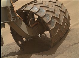 Wheel of the Curiosity rover partially submerged in sand at Hidden Valley (August 6, 2014).