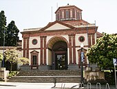 foto di un edificio di architettura classica, con colonne e frontone, a un piano, rosso e bianco, sormontato da una cupola esagonale