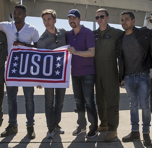 From left: Duane Henry, Brian Dietzen, Sean Murray (in purple), Wilmer Valderrama (at right), pictured with active duty airman, in uniform.