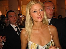 Smiling blonde woman, surrounded by people