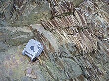 Pencil cleavage in limestone; surveying compass for scale Pencil Cleavage.JPG