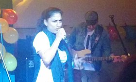 سميرة سرايا تغني على خشبة المسرح مع عضو في فرقة سيستم علي يعزف على الغيتار في الخلفية