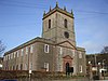 A rendered church seen from the northwest with two tiers of rectangular windows and an embraced west tower surmounted by pinnacles