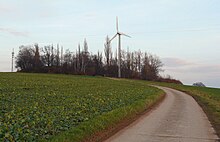 Kuppe des Höhenzugs mit Gehölz, Mobilfunkmast und Windkraftanlage (2009)